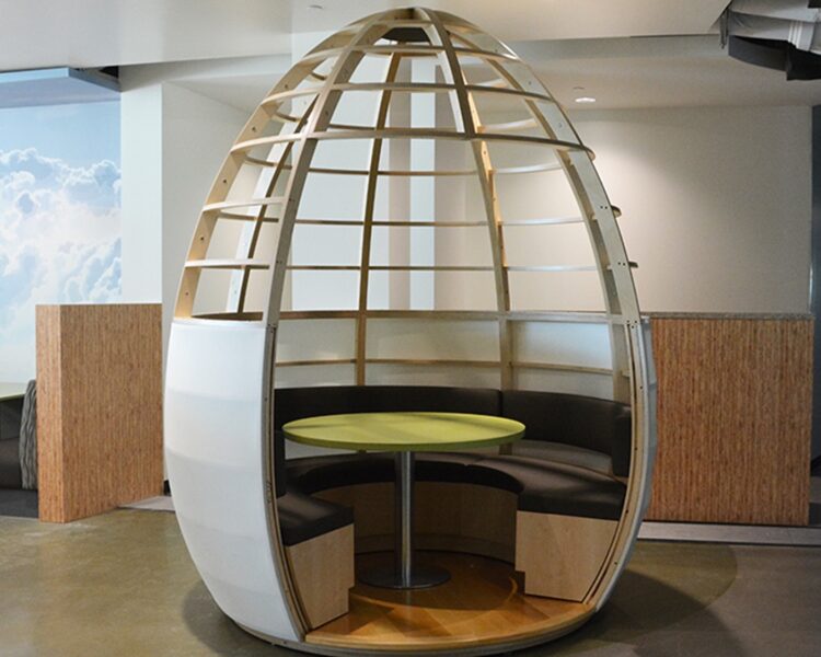 A freestanding egg-shaped banquette with a round table in the center